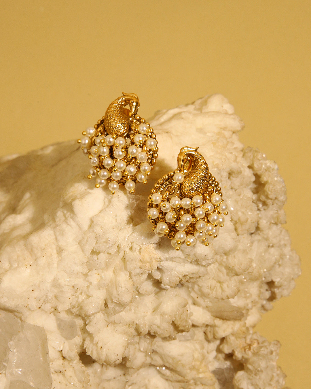 Sunehri gold tone peacock stud earrings with pearls